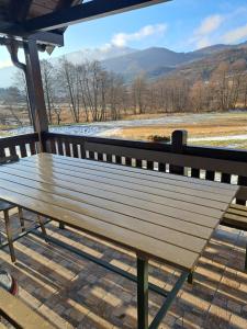 a wooden bench sitting on a porch with a view at Mokrogorska kuca in Mokra Gora
