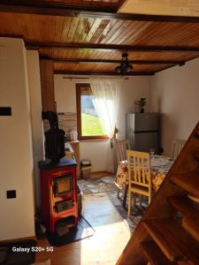 a living room with a wood stove and a table at Vikendica "Šapat šume" in Bosansko Petrovo Selo