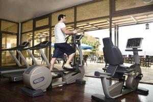un hombre corriendo en una cinta de correr en un gimnasio en DeadSea view apartments Samarah Resort E22 en Amán