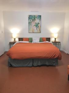 een slaapkamer met een groot oranje bed met 2 lampen bij Aloha Hotel Palm Springs in Palm Springs