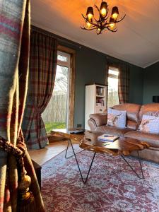 sala de estar con sofá y mesa en Hunters Glebe Lodge, en Castlerock