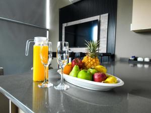 un bol de fruta y dos vasos de zumo de naranja en The Anza Lifestyle Lodge, en Louis Trichardt