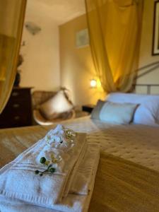 a bed with a towel with flowers on it at Ca' Datu in Finale Ligure