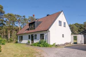 uma casa branca com um telhado castanho em Hela huset västerhejde em Visby