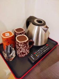 a tray with a tea pot and cups and a remote control at HOTEL YTS in Brinchang