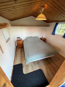 um quarto com uma cama num quarto com pisos em madeira em Hela huset västerhejde em Visby