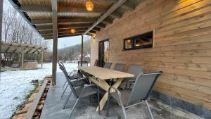 Une table et des chaises en bois sont disponibles sur la terrasse. dans l'établissement A Sziget, à Izvoare