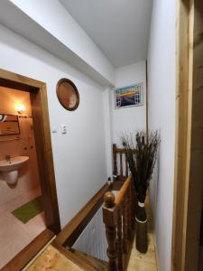 um corredor com um lavatório e um relógio na parede em Grand Central House em Odorheiu Secuiesc