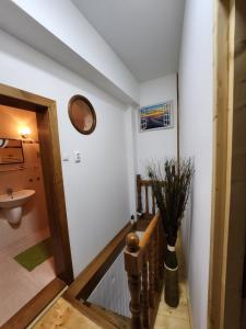 a hallway with a sink and a clock on the wall at Grand Central House in Odorheiu Secuiesc