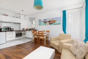 a kitchen and living room with a couch and a table at Maritime Cosy Apartment in Świnoujście