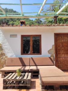 un patio con 2 bancos y una ventana en Trocito de Paraíso en la Sierra Espadán en Eslida
