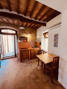 a kitchen with a wooden table and a dining room at La Casina BFF in Magliano in Toscana +7 photos