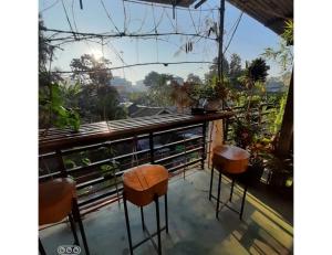 d'un balcon avec deux tabourets et vue sur la ville. dans l'établissement Hearth of Imphal, Manipur, à Imphal