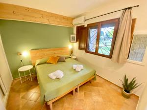 a bedroom with a green bed and a window at Residence La Rosa in Porto San Paolo