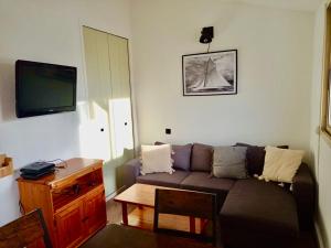 salon z kanapą i telewizorem w obiekcie Superbe T3 climatisé calme Marina canet 2 min de la plage w mieście Canet-en-Roussillon