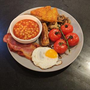 a plate of food with eggs bacon tomatoes and beans at White House in Lytham St Annes