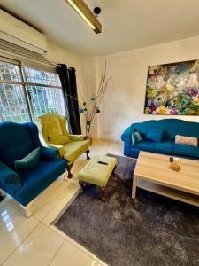 een woonkamer met twee blauwe banken en een tafel bij Vintage/Modern 3BR Apt+Huge Discount@Madinaty in Madinaty