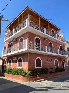 a red brick building with a white balcony at House of Flora in Saint-Louis