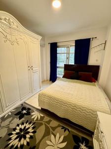een slaapkamer met een bed en een groot raam bij Vintage/Modern 3BR Apt+Huge Discount@Madinaty in Madinaty