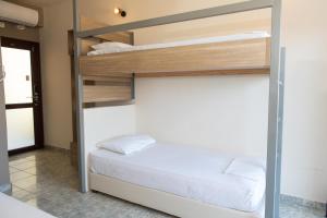a bedroom with a bunk bed with white sheets at Tota Marinou in Trikovilón