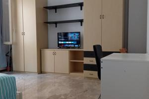Zimmer mit einem TV und einem Schreibtisch mit Stuhl in der Unterkunft casa bilocale in centro vicino stazione in Voghera