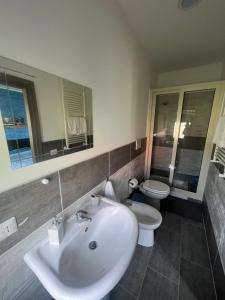 a bathroom with a white sink and a toilet at Etna &Vita in San Giovanni la Punta +12 photos