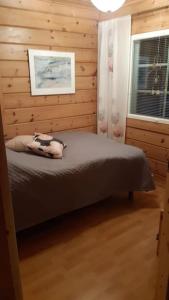 a bedroom with a bed in a wooden room at Villa Ojala, a lovely cottage with own beach in Kuusamo