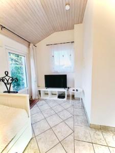 a living room with a television and a couch at Skyview Studio Peaceful Retreat near Luxemburg Airport in Niederanven