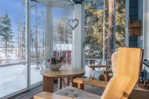 un porche cubierto con mesa y sillas en Villa Ojala, a lovely cottage with own beach, en Kuusamo