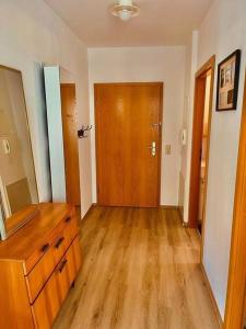 an empty room with a dresser and a wooden door at Sonniges Apartment in ruhiger und zentraler Lage in Pforzheim