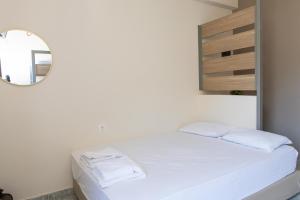 a bedroom with a white bed and a mirror at Tota Marinou in Trikovilón