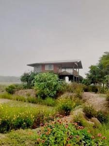 ein Haus auf einem Feld mit Blumen in der Unterkunft Banrai Tator Phophiang in Ban Nong Khan