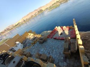 an aerial view of a table with chairs next to the water at Go Inn Backpackers in Aswan