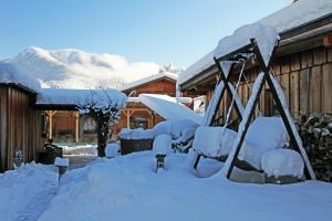 a playground covered in snow in front of a house at Hotel Staudacherhof History & Lifestyle in Garmisch-Partenkirchen