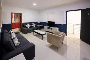 een woonkamer met een bank en een tv bij BRAGHA APARTMENTS in Takoradi