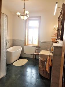 bagno con vasca, lavandino e finestra di Superior-Komfort-Suite-90m2-bis-5-Personen-im-Jugendstil-Gruenderzeit-Villa-im-Harz a Sankt Andreasberg