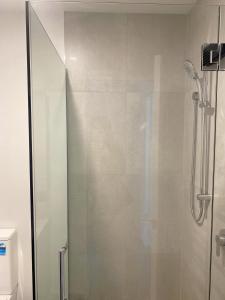 una ducha con puerta de cristal en un baño en addington luxury townhouse, en Christchurch