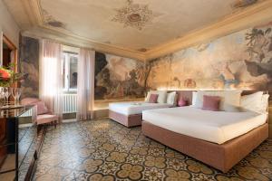 two beds in a room with a painting on the wall at Piazza Pitti Palace - Residenza d'Epoca in Florence