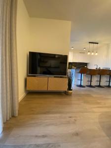 un soggiorno con una grande TV su una parete di Luxury & cozy apartment a Lubbeek