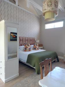 - une chambre avec un lit doté d'oreillers et d'un miroir dans l'établissement The White Bloom Villa, à Langebaan
