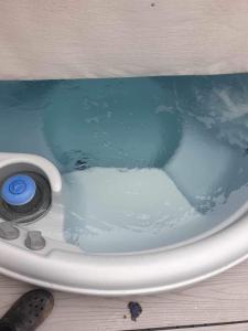 une baignoire remplie d'eau bleue assise sur une table dans l'établissement hot tub luxury caravan 23 Lancaster tattershall lakes, à Tattershall