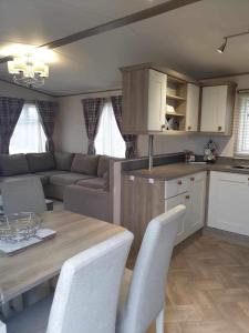uma cozinha e sala de estar com mesa e cadeiras em hot tub luxury caravan 23 Lancaster tattershall lakes em Tattershall