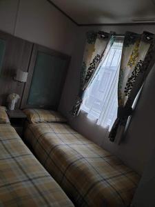 1 Schlafzimmer mit 2 Betten und einem Fenster in der Unterkunft hot tub luxury caravan 23 Lancaster tattershall lakes in Tattershall