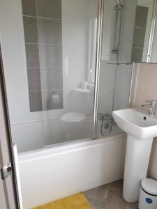 a white bathroom with a shower and a sink at hot tub luxury caravan 23 Lancaster tattershall lakes in Tattershall