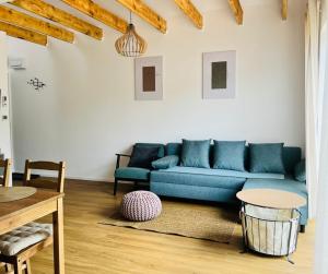 een woonkamer met een blauwe bank en een tafel bij Osada Hygge in Gostynin