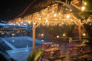 New DGYP Ciater Resort في تْشياتِر: مجموعة طاولات وكراسي بجانب مسبح