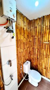 a bathroom with a toilet and a wooden wall at New DGYP Ciater Resort in Ciater