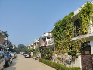 eine Straße mit Autos, die an der Seite eines Gebäudes geparkt sind in der Unterkunft Osho home in Lucknow