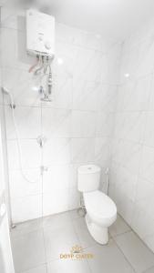 y baño blanco con aseo y ducha. en New DGYP Ciater Resort, en Ciater