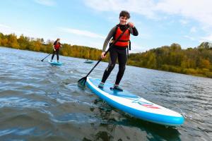 two people are paddle boarding on the water at Modern boutique apartment for 4- central Ellesmere in Ellesmere